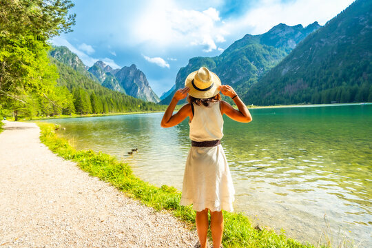 Tourist enjoying breathtaking view of lake dobbiaco in the dolomites