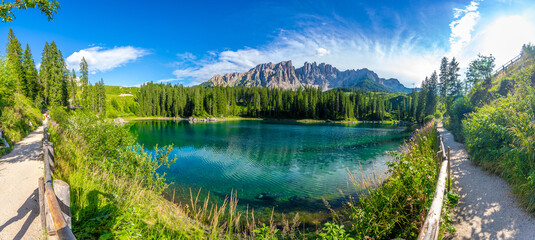 Karersee, dolomites, stunning panoramic view of lake and latemar mountain range in summer
