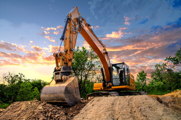 A stopping yellow excavator at an incredibly beautiful sunset