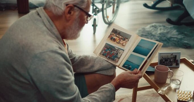 Grandfather reminisces about his youth by looking at an old photo album with photos from his past