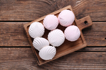 Delicious marshmallows on cutting board on wooden background. Top view