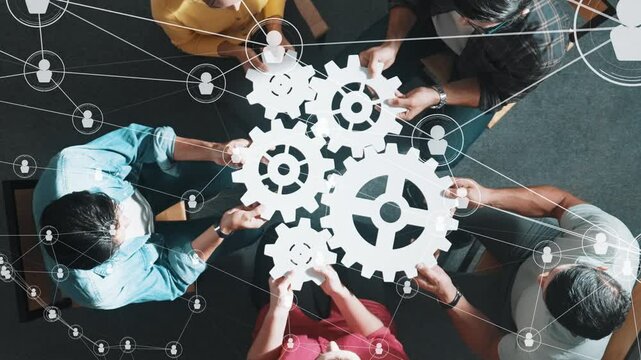 Top view of skilled business people joining and gathering white gear together. Diverse team working together to put or collect cog with networking communication and data base connection. Symposium.