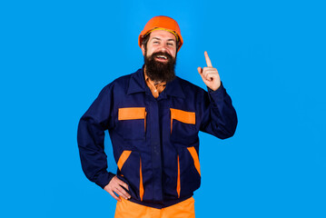Male builder in hard hat and uniform pointing finger up having great idea and plan. Industrial worker in safety helmet pointing finger up. Building solution. Happy bearded man in construction hardhat.