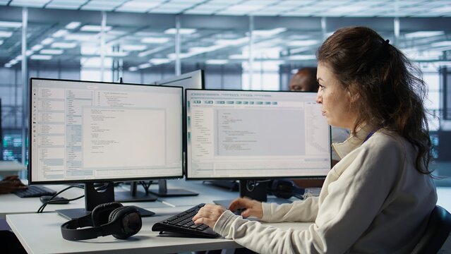 IT professional in server hub ensuring valuable data remains shielded from potential threats using PC. Employee safeguarding data center against unauthorized access and vulnerabilities, camera B