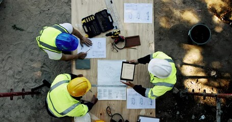 Top view, architect and team planning on tablet with blueprint for construction project or development. Engineer group, tech and people with design for building, discussion and brainstorming at site