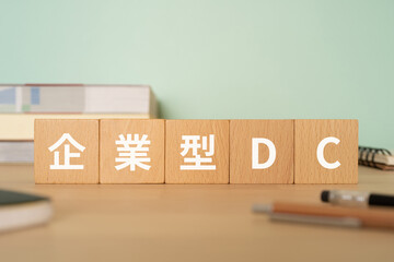 企業型DCの文字が入ったブロックが置かれたデスク