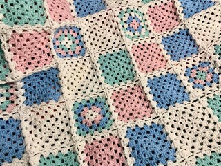 Granny square crocheted blanket with different colors motives, retro vintage craft handmade handiwork crocheting, beautiful plied photo cozy winter or autumn background wool thing yarn lovely warm