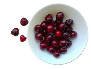 Red cherries in a white bowl. Isolated