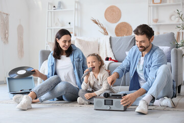 Fototapeta premium Happy family with microphone and radio system singing karaoke at home