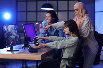 Obraz premium Young women playing computer game in club at night