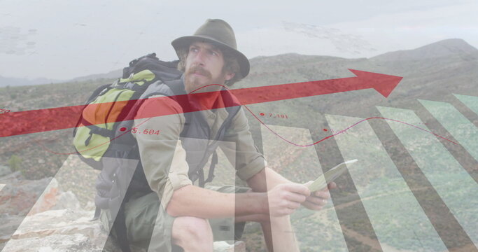 Image of financial data processing over caucasian man reading map in mountains