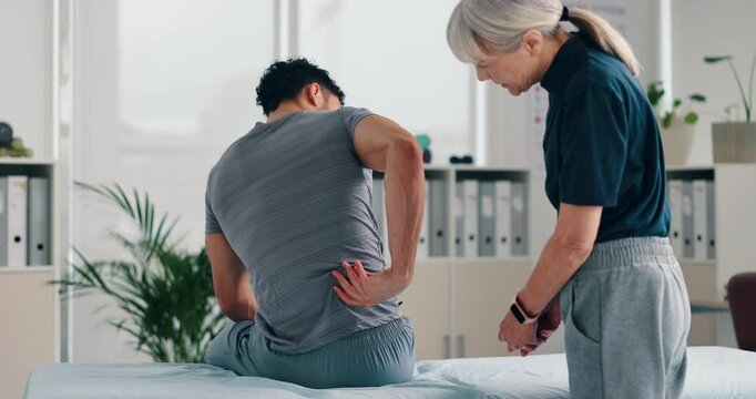 Man, patient and talking with physiotherapist for back injury, bad posture or muscle tension at clinic. Chiropractor, physio or therapist listening to client with sore spine for checkup at practice