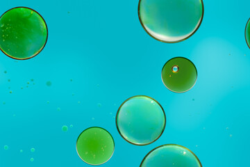 Abstract green oil circles floating on blue background