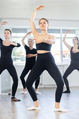 Obraz premium Group of slender women of different ages are learning various dance and ballet movements in the studio
