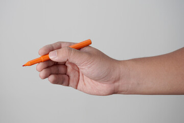 Male person hand holding pen writing, over grey