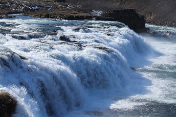 A powerful Icelandic waterfall flowing into a rugged canyon.