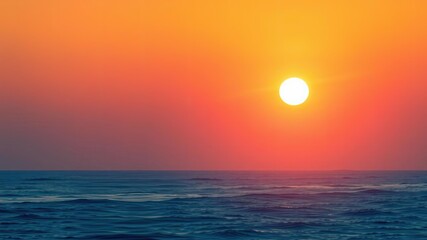 Gradual transition from dark blue to soft pink as the sun rises above the horizon casting a warm glow on the ocean's surface, peaceful, nature