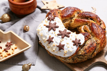 Wooden board with tasty Christmas pastry wreath, decor and cookies on white background
