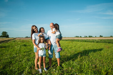 The family spends leisure time in the fresh air.Three sisters are playing in nature in the grass.