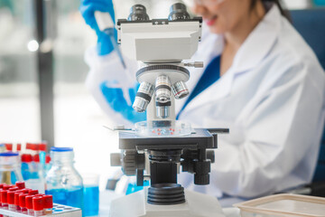 A young Asian woman works in a laboratory, conducting chemical and blood tests. Wearing goggles, research and analysis, combining science and technology in a professional and medical environment.