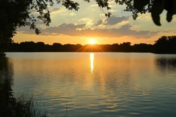 Obraz premium A serene sunset over a tranquil lake, reflecting warm colors.