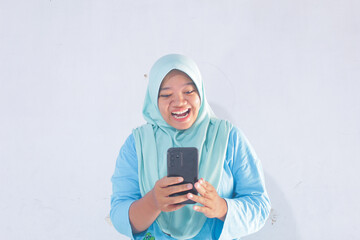 Fototapeta premium Happy Blue Hijab Woman Holding Smartphone on White Background