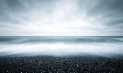 Obraz premium A serene seascape with gentle waves under a cloudy sky.