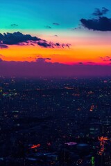 Fototapeta premium A vibrant sunset over a cityscape, showcasing colorful skies and lights.