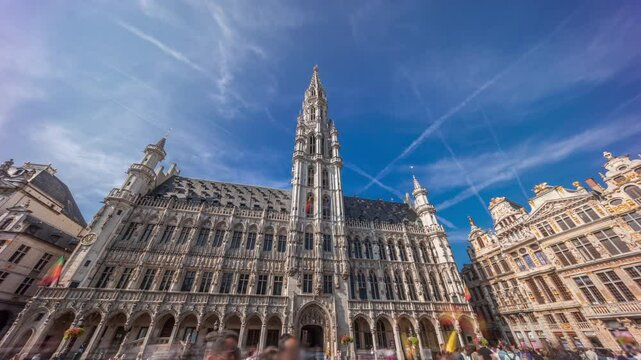 Timelapse hyperlapse of Town Hall (Hotel de Ville) on the Grand Place in Brussels, Belgium. Looking up at the Gothic tower and facade. A UNESCO World Heritage Site and major tourist destination