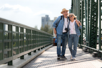 Elderly couples travel on the old iron bridge (Phra Phutthayotfa Bridge) in Bangkok, Thailand