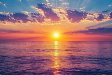 Obraz premium A vibrant sunset over the ocean, casting colorful reflections on the water.