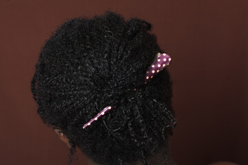 Black 4c hair in mini twists held with a hair clip, mini twist protective hairstyle, natural curly hair in frizzy mini twists