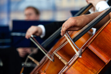 Close-up of a musician's hand playing the cello in an orchestra