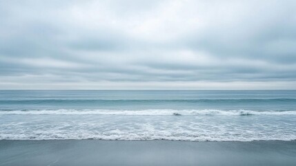 Fototapeta premium A serene coastal scene with gentle waves and overcast skies.