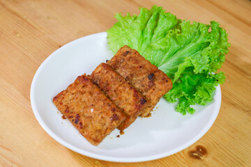 Tempe Bacem is a traditional food of Central Java, the tempeh is flavored with brown sugar and then fried, served on wicker bamboo plate