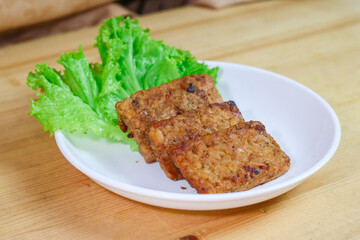 Tempe Bacem is a traditional food of Central Java, the tempeh is flavored with brown sugar and then fried, served on wicker bamboo plate