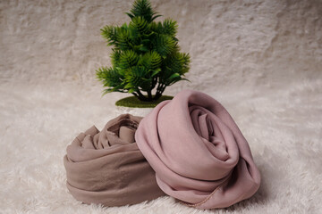 A rolled hijab in soft colors isolated on a white background. Hijab mockup and high resolution photos.