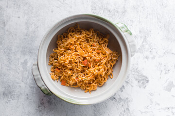 Overhead view of Spicy instant noodles in a claypot, spicy ramen noodles in a donabe