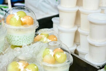 Tapioca pandan pudding with coconut cream and fresh fruit (melon, strawberry, kiwi, orange) for sale at Soi 20, an open street market selling fresh produce and street food in Silom - Bang Rak, Bangkok