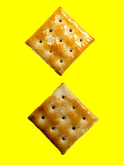 two cracker biscuits placed separatey on yellow background