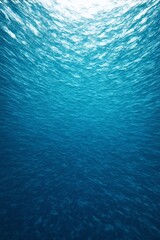 a close up of a blue ocean with a sun shining through the water