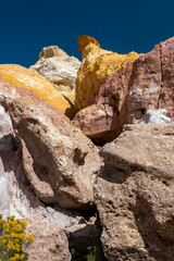 Exploring the vibrant rock formations in a remote desert landscape during a clear daytime sky, showcasing stunning colors and unique geological features