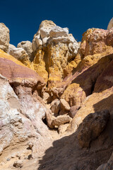 Fototapeta premium Unique geological formations featuring vibrant colors and textures at a natural rock landscape in a rugged terrain during bright daylight