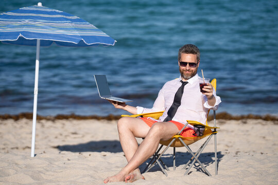 Remote online working on summer sea beach. Business man with laptop during tropical beach vacation. Leisure weekend and remote freelance work. Crazy comic businessman rest on sea beach.