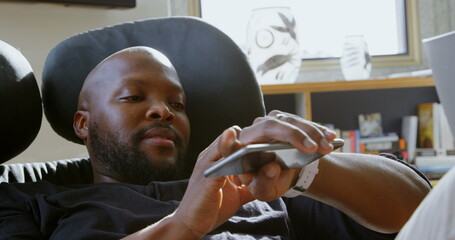 Side view of African american man using smartwatch in a comfortable home