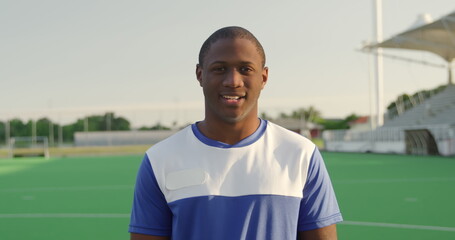 Portrait close up of an African American male field hockey player, wearing a blue team strip, standi