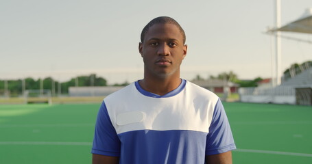 Portrait close up of an African American male field hockey player, wearing a blue team strip, standi