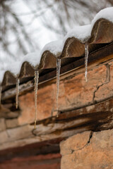 Icicles on the roof. Winter concept. High quality photo.