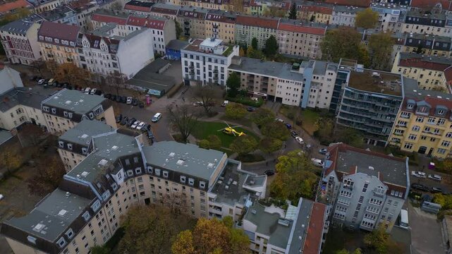 Yellow ADAC helicopter at residential building in berlin, germany, demonstrating the importance of emergency services. Wonderful aerial view flight