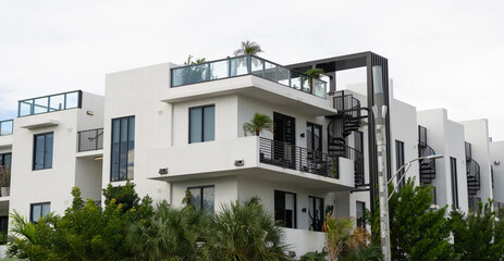 Apartment building with balconies and palm trees. View of building. Residential building architecture. Architectural exterior. House exterior fragment. Modern apartment building. Summer vacation